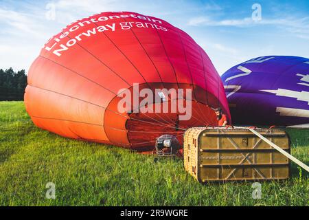 Vol en montgolfière au-dessus de Trakai. Gonfler le ballon d'air chaud dans un champ vert avant le vol au-dessus de Trakai, Vilnius, Lituanie Banque D'Images