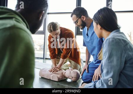 Réanimation cardiopulmonaire, jeune homme effectuant des compressions thoraciques sur un mannequin de RCP pendant l'apprentissage pratique du séminaire de formation aux premiers soins près de Medical i Banque D'Images