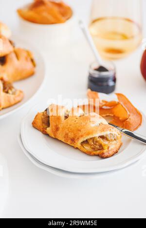 Petits pains à la cannelle et à la pomme sur une table en bois blanc Banque D'Images