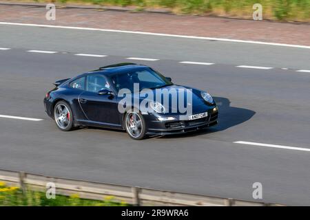 2007 Noir Porsche 911 Carrera 2 S Gray car coupé essence 3824 cc ; se déplaçant à vitesse rapide sur l'autoroute M6 dans le Grand Manchester, Royaume-Uni Banque D'Images