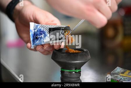 Sindelfingen, Allemagne. 29th juin 2023. Un tuyau d'eau de nargua est rempli de tabac dans un bar de nargua. Les bars de shisha dominent de plus en plus le paysage urbain dans de nombreuses villes. Mais le marché du narguilé souffre de trop de règles et de bureaucratie, critiquant les jeunes libéraux du Bade-Wurtemberg. (À dpa "les jeunes libéraux critiquent la bureaucratie pour les barres de nargua") Credit: Bernd Weißbrod/dpa/Alamy Live News Banque D'Images