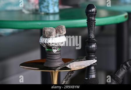 Sindelfingen, Allemagne. 29th juin 2023. Des morceaux de charbon pour chauffer le tabac se trouvent sur un tuyau d'eau de nargua dans un bar de nargua. Les bars de shisha dominent de plus en plus le paysage urbain dans de nombreuses villes. Mais le marché du narguilé souffre de trop de règles et de bureaucratie, critiquant les jeunes libéraux du Bade-Wurtemberg. (À dpa "les jeunes libéraux critiquent la bureaucratie pour les barres de nargua") Credit: Bernd Weißbrod/dpa/Alamy Live News Banque D'Images