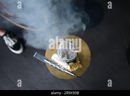 Sindelfingen, Allemagne. 29th juin 2023. Des morceaux de charbon pour chauffer le tabac se trouvent sur un tuyau d'eau de nargua dans un bar de nargua. Les bars de shisha dominent de plus en plus le paysage urbain dans de nombreuses villes. Mais le marché du narguilé souffre de trop de règles et de bureaucratie, critiquant les jeunes libéraux du Bade-Wurtemberg. (À dpa "les jeunes libéraux critiquent la bureaucratie pour les barres de nargua") Credit: Bernd Weißbrod/dpa/Alamy Live News Banque D'Images