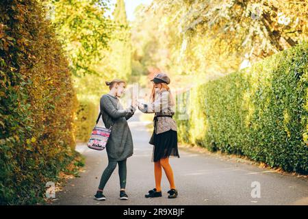 Portrait en plein air de deux filles de la préadolescence drôle portant des vêtements à la mode, la mode pour les adolescents. Les enfants dansent et s'amusent Banque D'Images