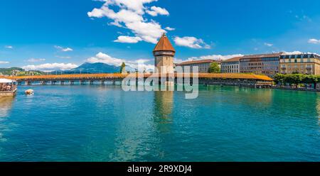 Photo panoramique pittoresque de la célèbre passerelle en bois couverte en diagonale, le Kapellbrücke (pont de la chapelle), avec la Tour d'eau sur la rivière... Banque D'Images