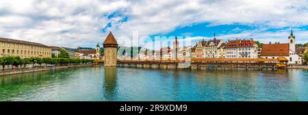 Vue panoramique sur la célèbre passerelle en bois couverte en diagonale Kapellbrücke (pont de la chapelle) avec la Tour de l'eau, enjambant la rivière Reuss en... Banque D'Images