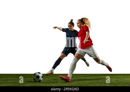 Deux jeunes filles, joueurs de football en mouvement, entraînement, dribbling ball sur fond blanc. École de sport Banque D'Images