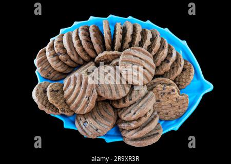 Vue de dessus des biscuits aux pépites de chocolat ou des biscuits sur l'assiette. Isolé sur fond noir. Mise au point sélective. Copier l'espace Banque D'Images