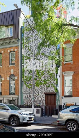 324 East 51st Street le lien avec ses voisins est que les perforations de sa façade métallique sont de la taille et de la forme des briques. Ivy a pris le dessus. Banque D'Images