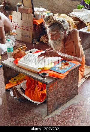 24 juin 2023, Sadhu, Indien de la vieillesse, lisant des Saintes Écritures à Ganagapura, Karnataka, Inde. Banque D'Images