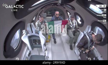 29 juin 2023: Images d'une vidéo publiée par Virgin Galactic montre que les membres italiens de l'équipe à bord de Unity tiennent le drapeau de leur pays dans l'espace. Une équipe de chercheurs italiens qui a atteint le bord de l'espace jeudi matin, volant à bord de l'avion propulsé par une fusée de Virgin Galactic alors que la compagnie se prépare pour des vols commerciaux mensuels. Le vol a été lancé à partir de Spaceport America dans le désert du Nouveau-Mexique, avec deux officiers de l'Armée de l'Air italienne et un ingénieur du Conseil national de recherches d'Italie, se concentrant sur une série d'expériences de microgravité pendant leurs quelques minutes de poids. Une seule pièce Banque D'Images