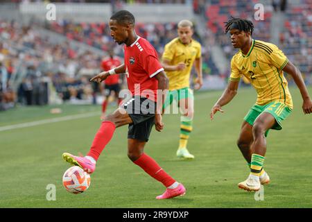 St. Louis, Missouri. USA; le défenseur de Trinité-et-Tobago, Shannon Gomez (14), dribbles le ballon sous la pression du défenseur jamaïcain Dexter Lembikisa (2) pendant Banque D'Images