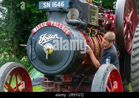 Dene Rally Steam and vintage show, 10th anniversaire du rallye en juin 2023, Hampshire, Angleterre, Royaume-Uni. Homme à polir le laiton sur un moteur de traction Banque D'Images