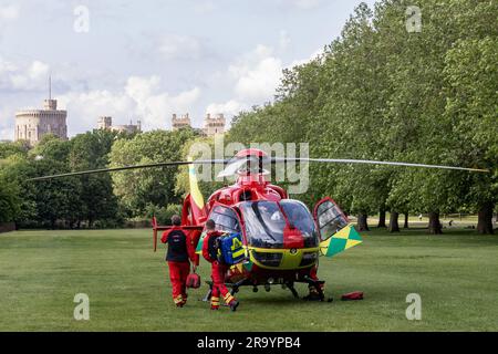 Windsor, Royaume-Uni. 21st juin 2023. Un équipage de Thames Valley Air Ambulance retourne à son nouvel Airbus 135 G-TVLY à côté de la longue promenade en face du château de Windsor après avoir assisté à un accident de la route à proximité. L'hélicoptère est entré en service en octobre 2022, a une vitesse de pointe de 135mph et est capable de rejoindre n'importe quelle partie du Berkshire, Buckinghamshire ou Oxfordshire en 15 minutes. Crédit : Mark Kerrison/Alamy Live News Banque D'Images