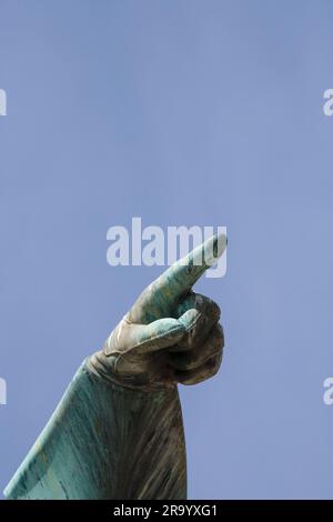 Gros plan de la main pointant l'index contre le ciel bleu. Statue de Karl XII roi de Suède à Kungstradgarden, Stockholm. Suède. Banque D'Images