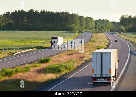 Vue arrière des véhicules sur la route de campagne avec des arbres en arrière-plan Banque D'Images