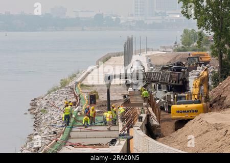 Detroit, Michigan - les travailleurs versent du ciment pour compléter une section de la promenade de Detroit sur le site de l'ancienne usine de pneus Uniroyal. La marche/le bi Banque D'Images