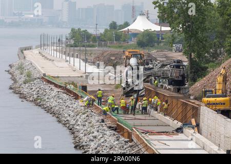 Detroit, Michigan - les travailleurs versent du ciment pour compléter une section de la promenade de Detroit sur le site de l'ancienne usine de pneus Uniroyal. La marche/le bi Banque D'Images