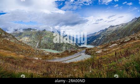 Photo panoramique d'une route désertique parmi les lacs laiteux et verts des Alpes suisses en automne. Magnifique paysage de montagnes en Suisse Banque D'Images