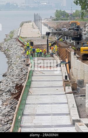 Detroit, Michigan - les travailleurs versent du ciment pour compléter une section de la promenade de Detroit sur le site de l'ancienne usine de pneus Uniroyal. La marche/le bi Banque D'Images