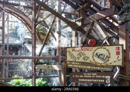 Panneau d'avertissement pour une montagne russe dans le parc à thème Tokyo DisneySea, Japon Banque D'Images