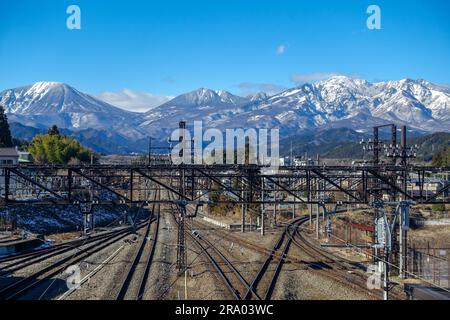 Gare de Nikko, rails, avec des Alpes japonaises enneigées dans le fond Banque D'Images