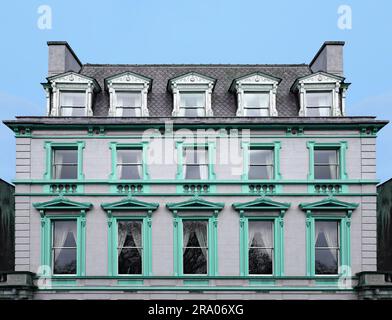 Ancien immeuble d'appartements avec toit en mansarde et cadres ornés autour des fenêtres Banque D'Images