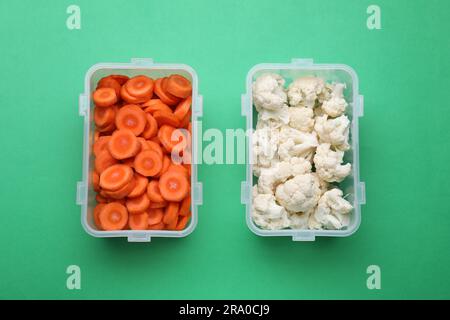 Récipients en plastique avec produits frais sur fond vert, à plat Banque D'Images