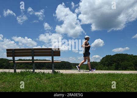 Un homme prend un air devant un banc de parc avec un fond bleu ciel à Raleigh, en Caroline du Nord. Banque D'Images