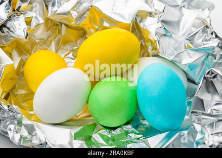 Peu de sucre coloré et des œufs en chocolat dans du papier aluminium pour célébration de Pâques Banque D'Images