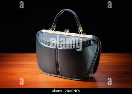 Du luxe et de la mode vintage Sac en cuir noir sur une table en bois Banque D'Images