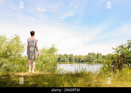 Une femme debout près du Dniepr à Kiev, Ukraine, observe dans la distance d'un point de vue, sous un ciel nuageux ciel d'été Banque D'Images