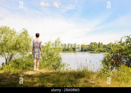 Une femme debout près du Dniepr à Kiev, Ukraine, observe dans la distance d'un point de vue, sous un ciel nuageux ciel d'été Banque D'Images