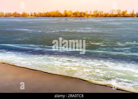 Blocs de glace sur le Dniepr gelé à Kiev pendant un hiver froid. Les arbres apparaissent dans la distance Banque D'Images