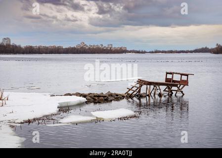 Quai de pêche sur le fleuve Dnieper à Kiev, Ukraine. Nuages lourds dans le ciel sombre d'hiver Banque D'Images