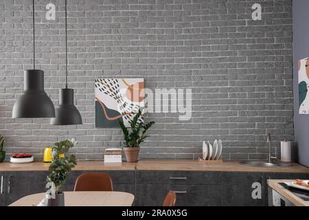 Intérieur de la cuisine moderne avec table à manger et comptoirs gris Banque D'Images