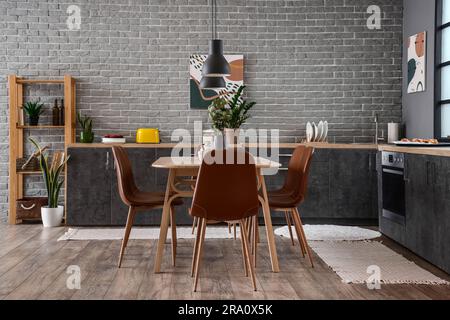 Intérieur de la cuisine moderne avec table à manger et comptoirs gris Banque D'Images