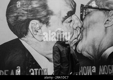 Berlin, Allemagne - 19 avril 2023 : vue d'un touriste regardant le mur de Berlin Allemagne, montrant Leonid Brejnev et Erich Honecker dans un fraternel Banque D'Images