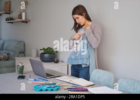 Une femme de race blanche en streaming montrant son design artistique dans une veste en denim. Des vêtements uniques. Banque D'Images