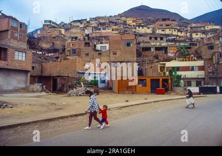 Pérou, mère et fille rentrent à la maison dans l'un des nombreux bidonvilles de Lima. Banque D'Images