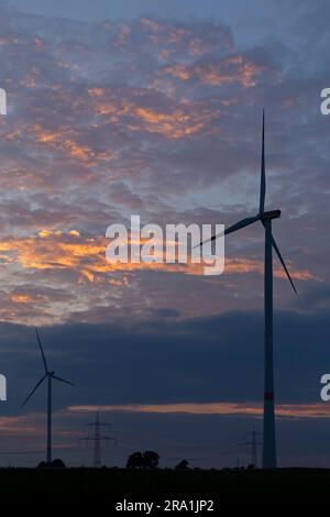 Centrales éoliennes et pylônes devant le ciel du soir, l'après-midi, le coucher du soleil, les nuages, Melbeck, Communauté commune d'Ilmenau, Basse-Saxe, Allemagne Banque D'Images