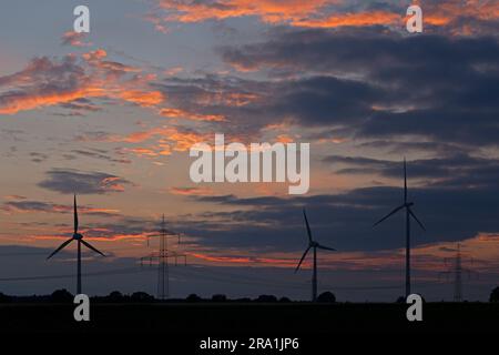 Centrales éoliennes et pylônes devant le ciel du soir, l'après-midi, le coucher du soleil, les nuages, Melbeck, Communauté commune d'Ilmenau, Basse-Saxe, Allemagne Banque D'Images