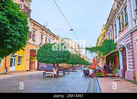 CHERNIVTSI, UKRAINE - 16 JUILLET 2021 : la ligne des temples verdoyants au milieu de la rue piétonne Olha Kobylyanska dans la vieille ville, sur 16 juillet à Chernivtsi Banque D'Images