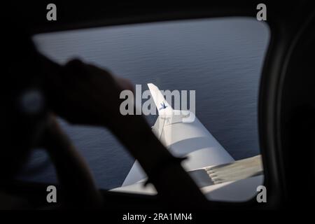 Lampedusa, Italie. 29th juin 2023. Une femme avec des jumelles de l'avion 'Colibri II' de l'organisation d'aide des ONG Pilotes Volontaires cherche des bateaux avec des migrants dans la mer Méditerranée entre Lampendusa et la côte nord-africaine. De la Tunisie, de plus en plus de réfugiés africains se croisent en Italie. Beaucoup de migrants paient un prix élevé pour le voyage, et pas seulement financièrement. Credit: Oliver Weiken/dpa/Alay Live News Banque D'Images