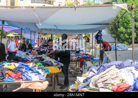 Sfax, Tunisie. 22nd juin 2023. Ousman de Gambie travaille dans une cabine pour les vêtements usagés à un marché aux puces. De plus en plus de réfugiés africains traversent la Tunisie vers l'Italie. De nombreux migrants paient un prix élevé pour le voyage, et pas seulement financièrement. Credit: Cindy Riechau/dpa/Alay Live News Banque D'Images