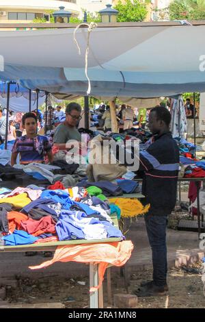 Sfax, Tunisie. 22nd juin 2023. Ousman de Gambie travaille dans une cabine pour les vêtements usagés à un marché aux puces. De plus en plus de réfugiés africains traversent la Tunisie vers l'Italie. De nombreux migrants paient un prix élevé pour le voyage, et pas seulement financièrement. Credit: Cindy Riechau/dpa/Alay Live News Banque D'Images