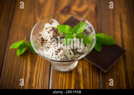 glace maison avec morceaux de chocolat noir râpé, dans un bol sur une table en bois. Banque D'Images