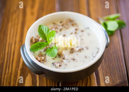 sarrasin bouilli avec lait et beurre pour le petit déjeuner, dans un bol sur une table en bois. Banque D'Images