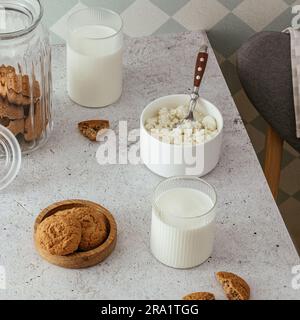 lait dans un verre ? fromage cottage dans un bol sur la table. Banque D'Images