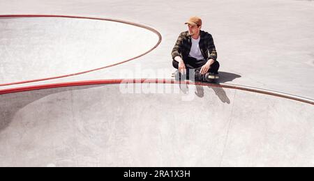 un patineur à roulettes agressif qui se rafraîchite dans un parc à roulettes Banque D'Images